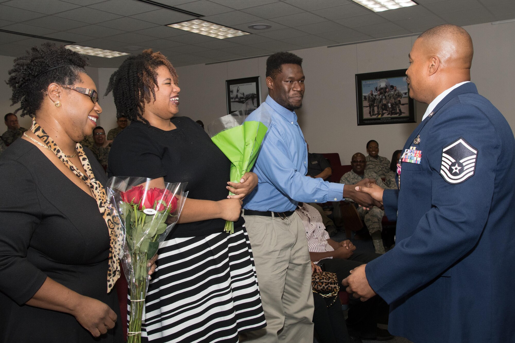 Master Sgt. Donald Brayboy Jr., a client support technician assigned to the 307th Force Support Squadron, Presents his son, Donald Brayboy III, with a coin during his retirement ceremony at Barksdale Air Force Base, La., Nov. 4, 2017.