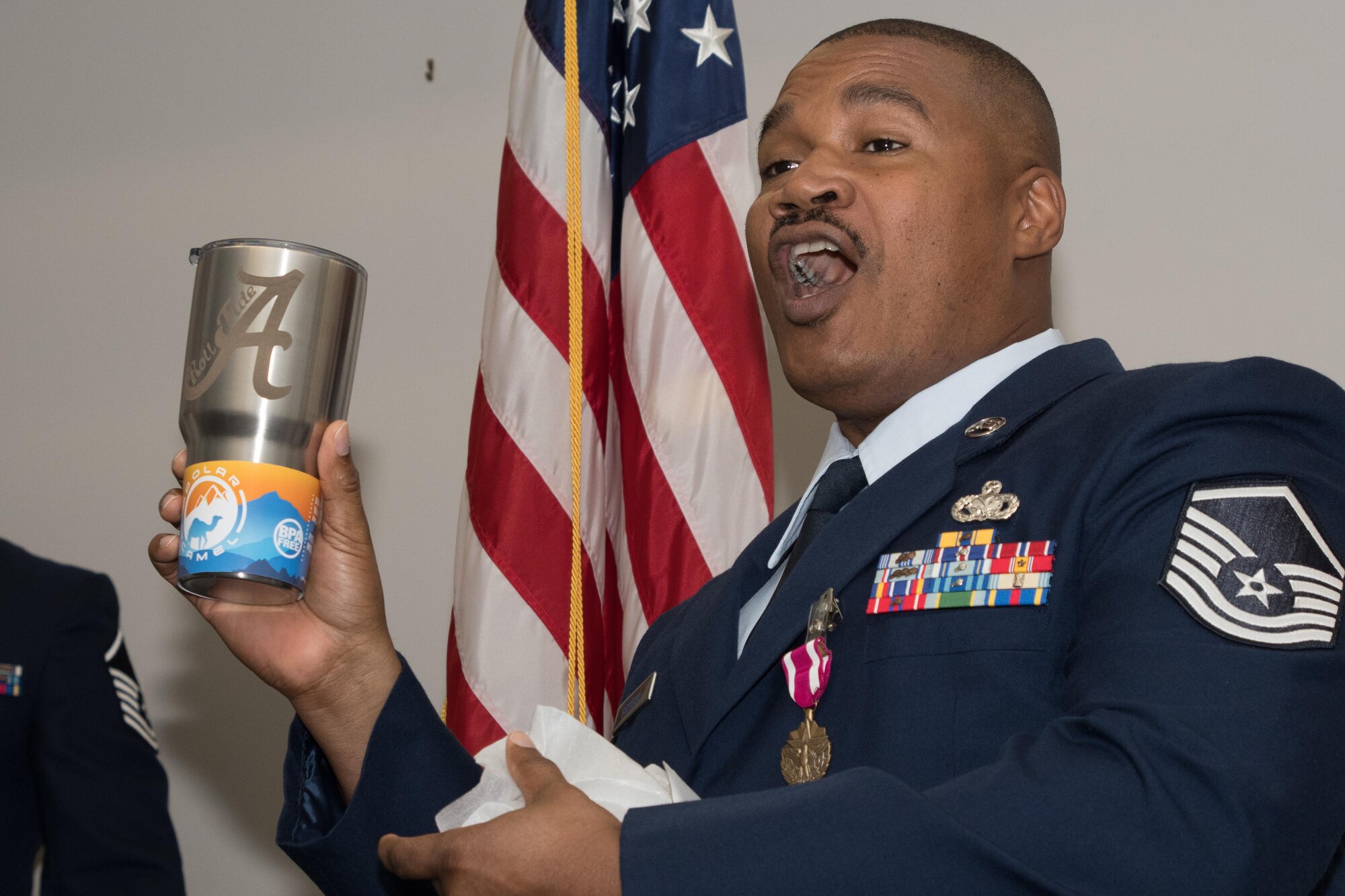 Master Sgt. Donald Brayboy Jr., a client support technician assigned to the 307th Force Support Squadron, calls “Roll Tide” after receiving an University of Alabama themed cup during his retirement ceremony at Barksdale Air Force Base, La., Nov. 4, 2017.