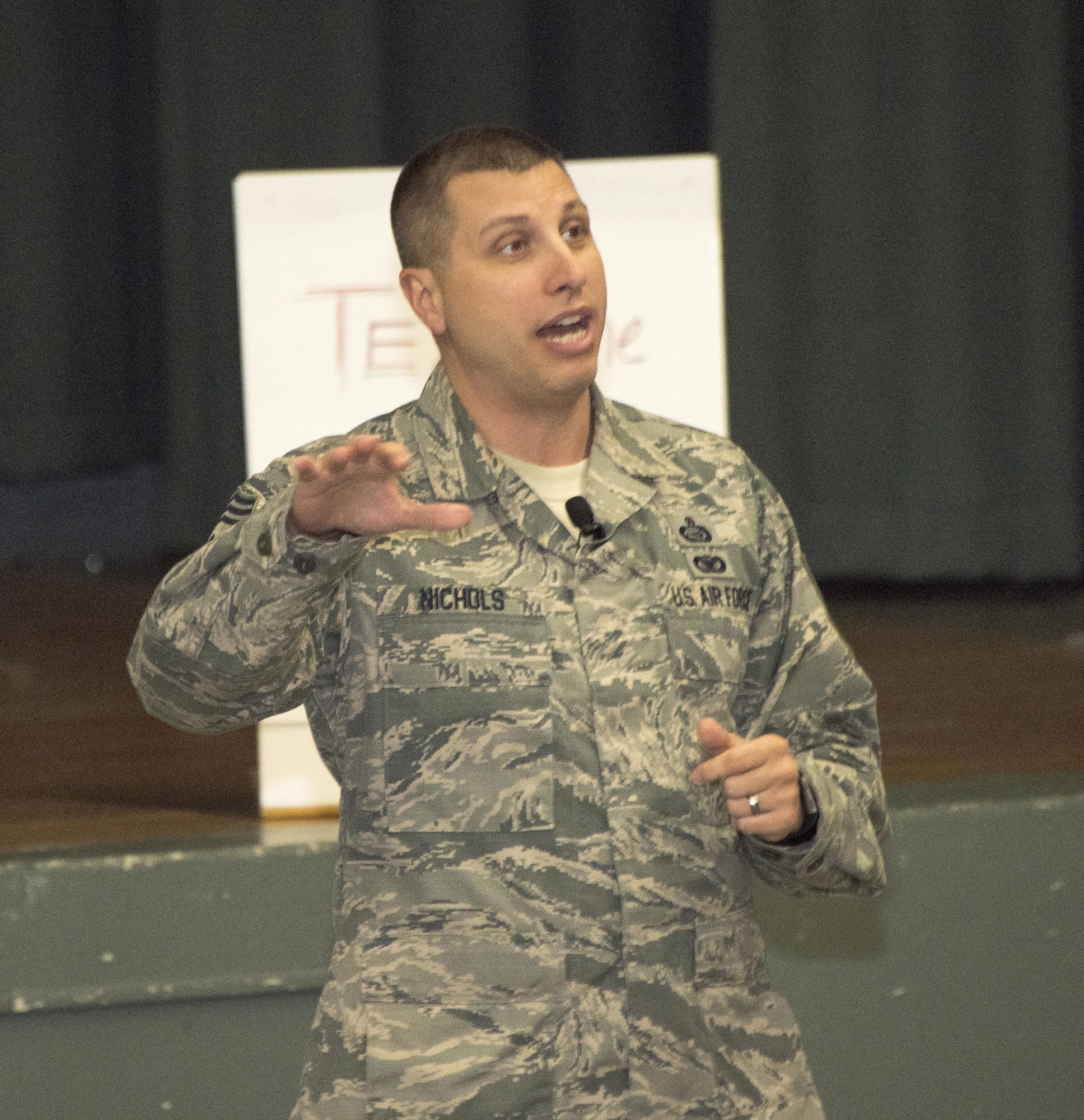 Chief Master Sgt. Steve Nichols, command chief for the 60th Air Mobility Wing, answers questions from the audience during an All Call at the Base Theater, Nov. 6, 2017, Travis Air force Base Calif. Airmen were able to use cell phones to text questions directly to the base commander and the command chief. (U.S. Air Force photo by Heide Couch)