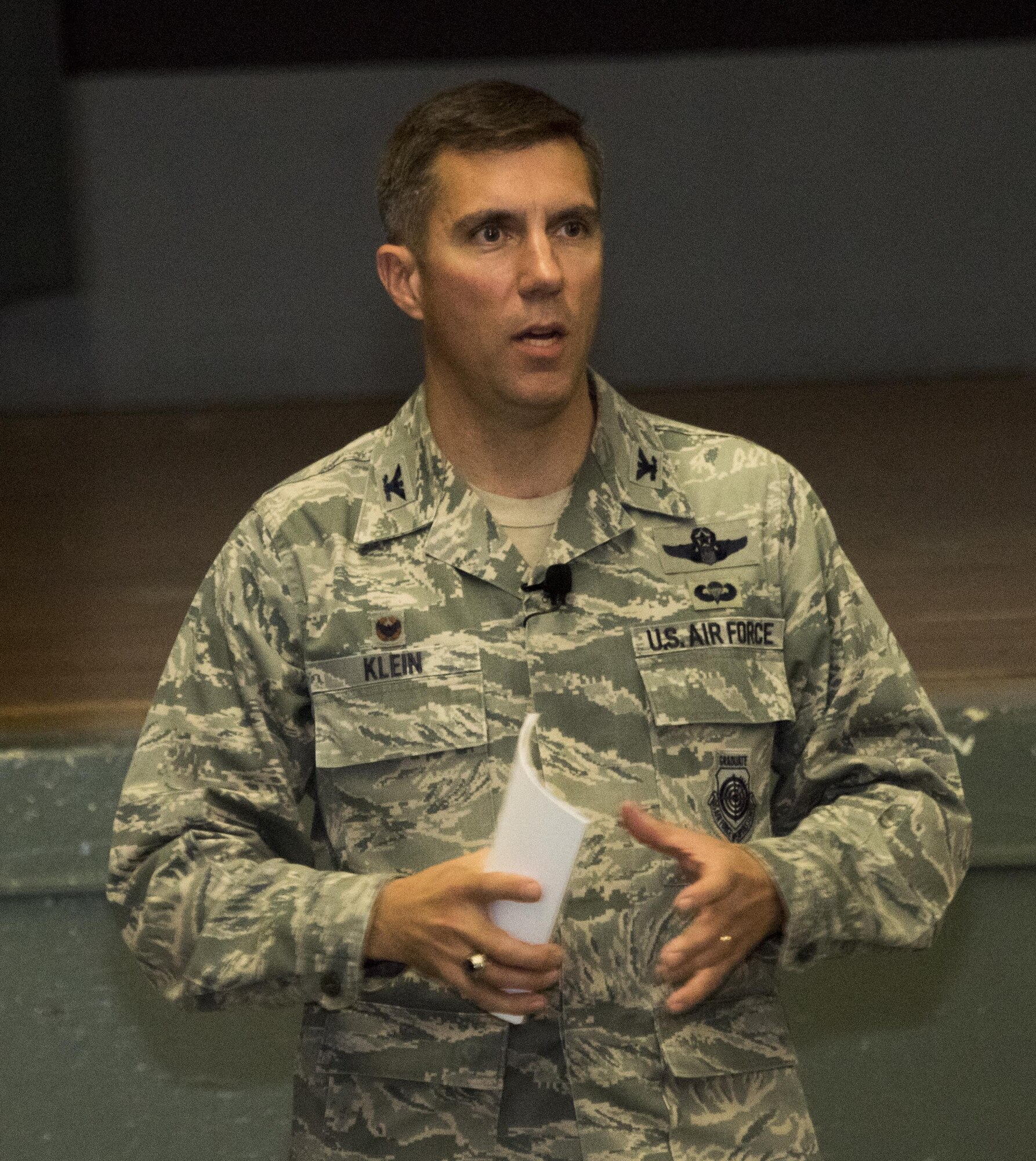 U.S. Air Force Col. John Klein, the commanding officer of the 60th Air Mobility Wing, addresses the audience during an All Call at the Base Theater, Nov. 6, 2017, Travis Air force Base Calif. Klein spoke about leadership, pride and maintaining readiness. (U.S. Air Force photo by Heide Couch)