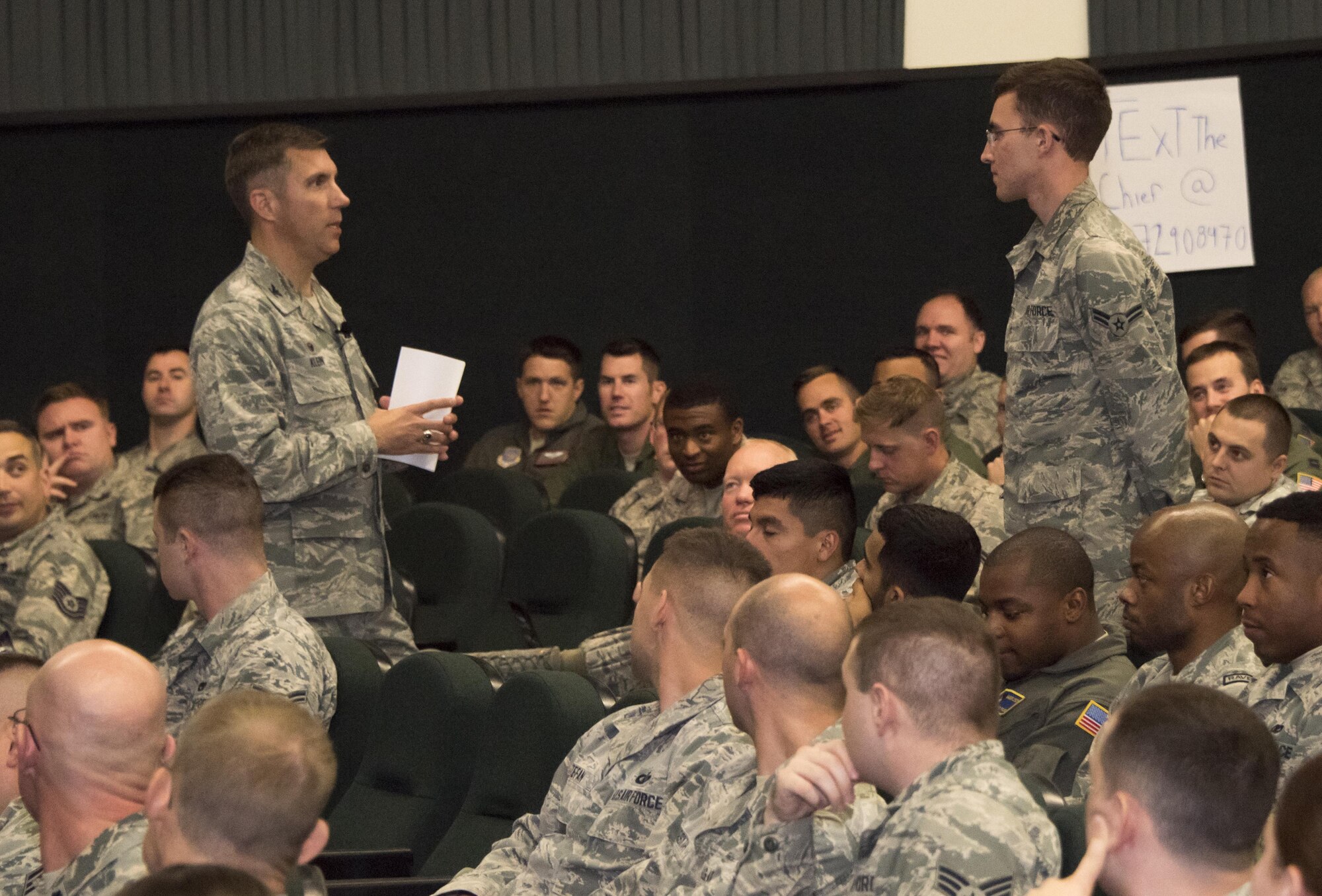 U.S. Air Force Col. John Klein, the commanding officer of the 60th Air Mobility Wing, askes an Airman about his training during an All Call at the Base Theater, Nov. 6, 2017, Travis Air force Base Calif. Klein spoke about leadership, pride, maintaining readiness and the Air Forces top priorities. (U.S. Air Force photo by Heide Couch)