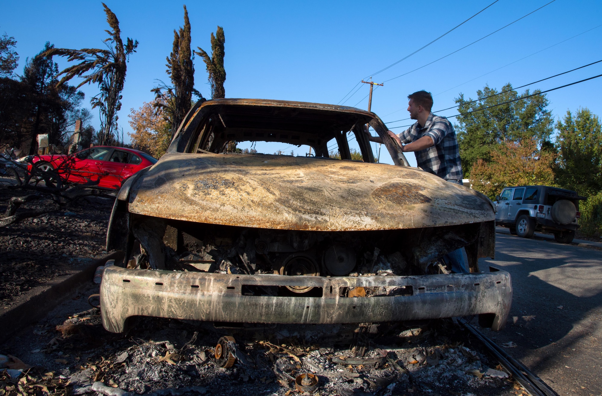 Senior Airman Martin Baglien, 349th Civil Engineer Squadron firefighter, inspects the shell of his father-in-law’s car after the California wildfire in Santa Rosa, Calif., on Oct. 31, 2017. Baglien was woken up by his family in the early hours of the morning after the wildfires started.