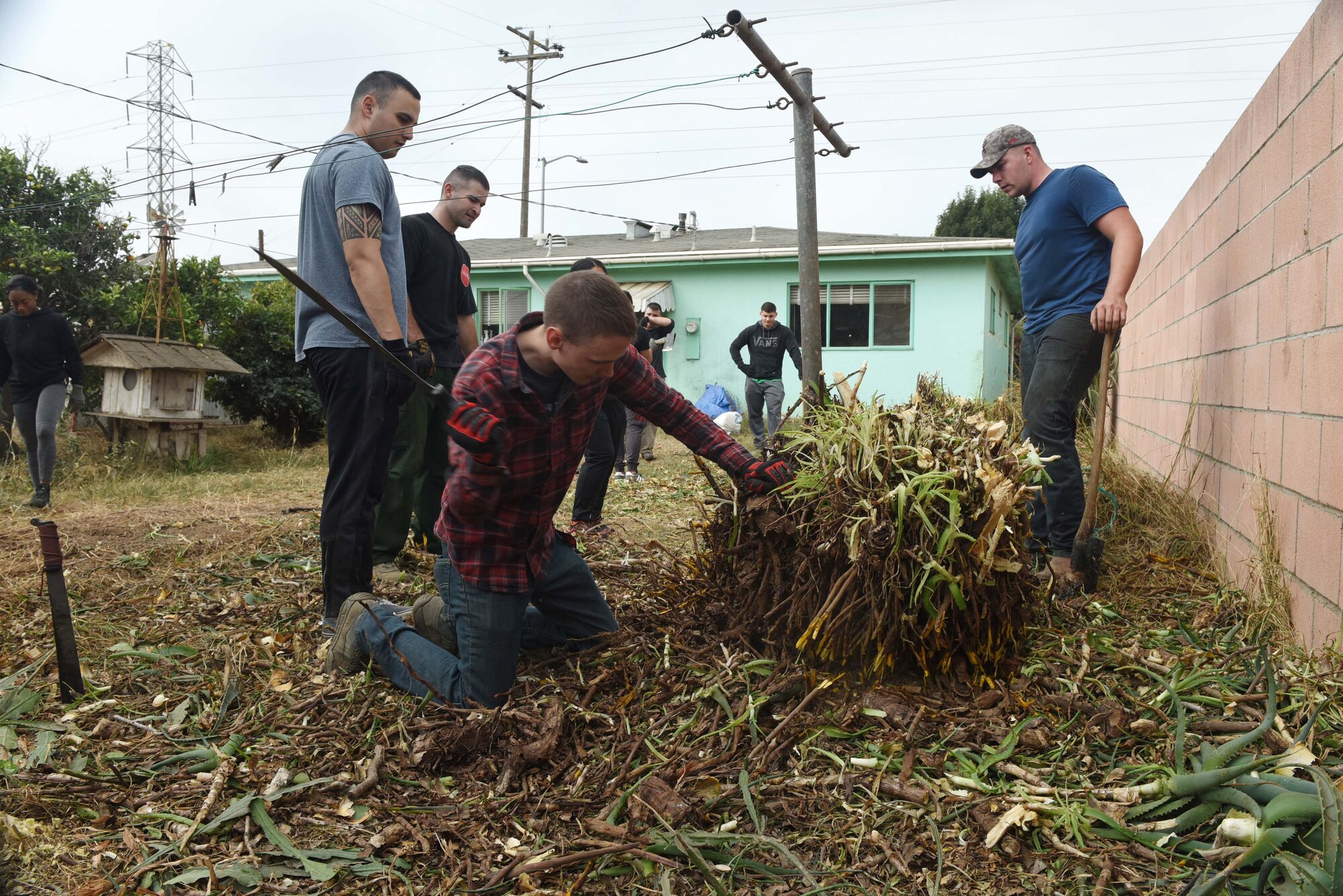 Vandenberg Airmen work together to support a Korean War veteran, Nov. 4, 2017, Santa Maria, Calif. The Airmen cleared out more than 6,000 pounds of green waste to save the Santa Maria home. (U.S. Air Force photo by Tech. Sgt. Jim Araos/Released)