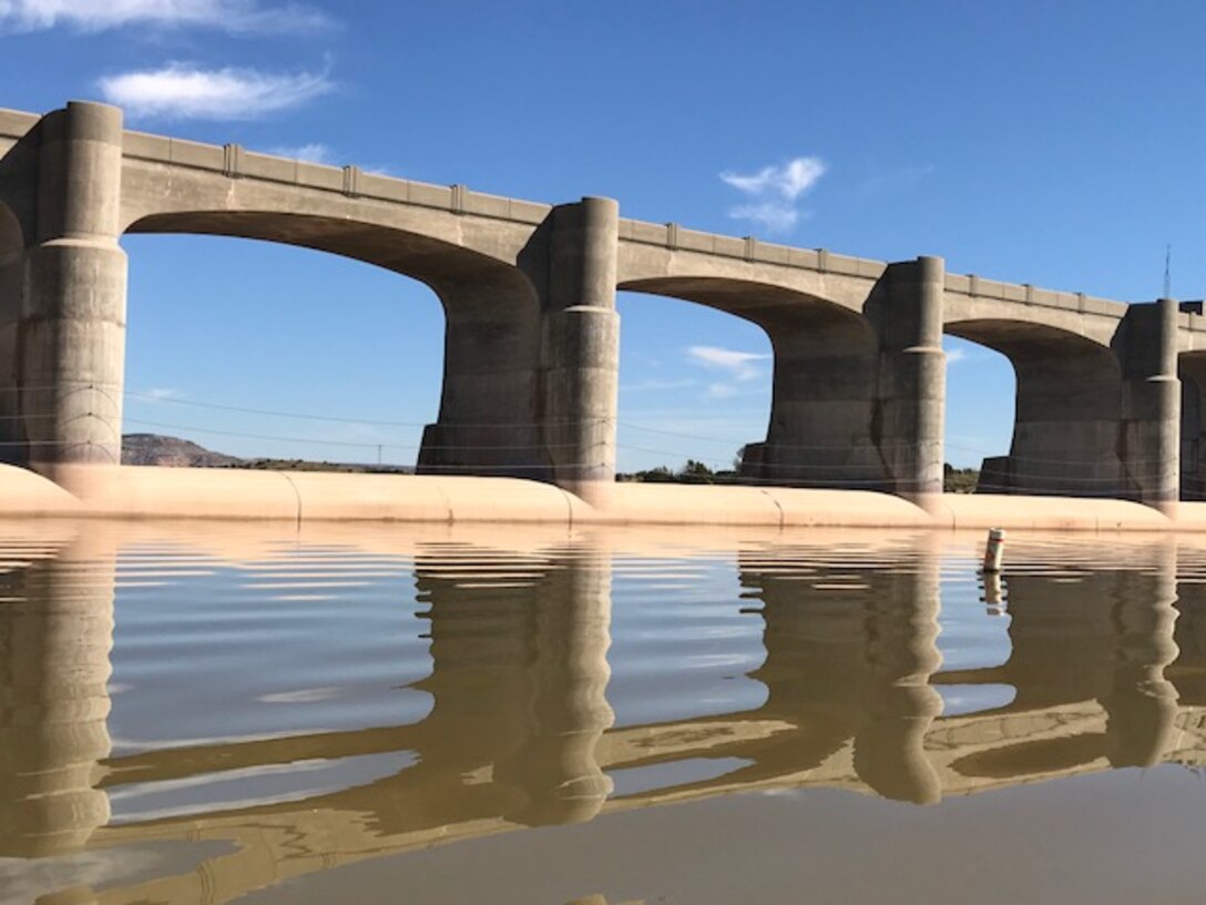 CONCHAS DAM, N.M. – The dam reflects in the lake, Oct. 17, 2017. The day was very calm with an elevation of 4195.22 and recent rains caused the water to be a muddy brown color.