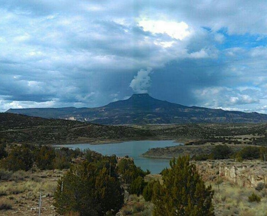 ABIQUIU LAKE, N.M. – Clouds appear to steam out like a volcano from the Cerro Pedernal in this photo taken from the Puerco campground, April 1, 2017. Photo by Clarence Maestas. This was a 2017 Photo Drive entry.