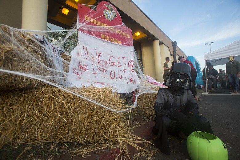 A child dressed as Darth Vader poses next to the Halloween-themed display during the Trunk-or-Treat event, Headquarters Battalion (HQBN), Marine Corps Base Hawaii (MCBH), Oct. 27, 2017. The event invited Marines, Sailors, and their families to dress up, decorate their vehicles, and attend the haunted house organized by the battalion’s family readiness officer and senior leadership. Social events hosted aboard MCBH accommodate a positive community which fosters, develops and promotes resiliency within the installation. (U.S. Marine Corps photo by Lance Cpl. Luke Kuennen)