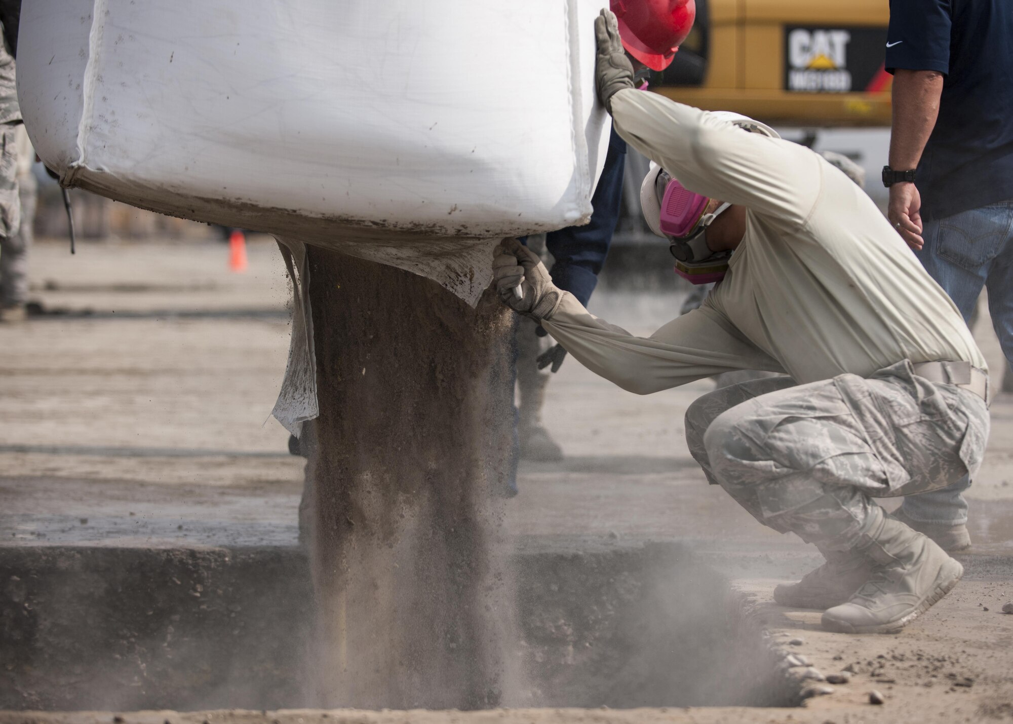 U.S. Air Force Staff Sgt. Ronald Jay Tabago, 8th Civil Engineer Squadron operations manager, cuts open a bag of rapid-set concrete during rapid airfield damage repair training at Kunsan Air Base, Republic of Korea, Oct. 25, 2017. Members from the Air Force Civil Engineer Center, Tyndall Air Force Base, Fla., instructed Airmen assigned to the 8th CES on the new RADR process. (U.S. Air Force photo by Staff Sgt. Victoria H. Taylor)