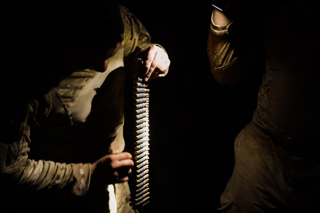 A soldier prepares an ammo belt before firing an M240 machine gun in Djibouti.