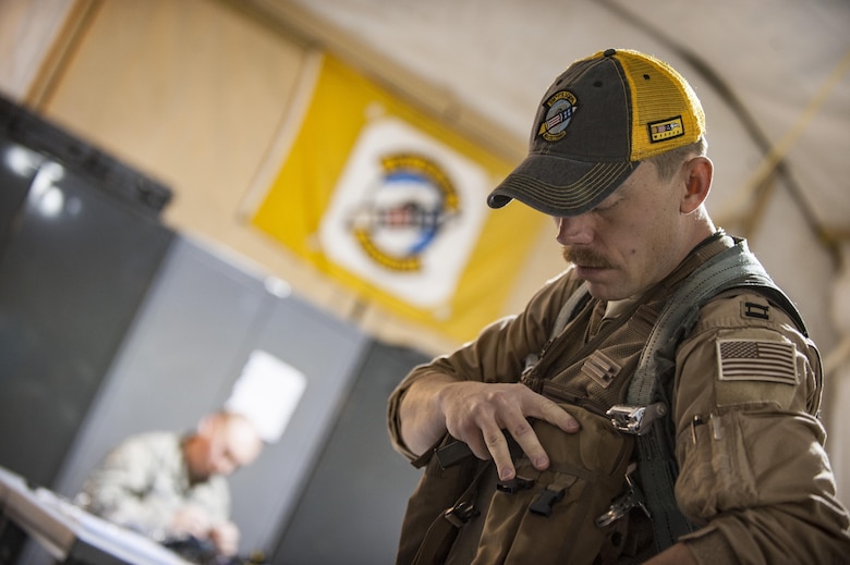 An aircrew member assigned to the 336th Expeditionary Fighter Squadron prepares his weapons and survival equipment for a sortie in support of Operation Inherent Resolve objectives November 7, 2017 in Southwest Asia.  In addition to the equipment required to safely operate high-performance combat aircraft, aircrew members also carry items designed to help them survive and get to safety in the event of a mishap. (U.S. Air Force photo by Senior Airman Joshua Kleinholz)