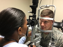 Dr. Nikki Meadows, 11th Medical Group Refractive Optometrist checks the health and stability of Capt Mark Kreul, patient, at the Warfighter Eye Center after completing refractive surgery.