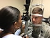 Dr. Nikki Meadows, 11th Medical Group Refractive Optometrist checks the health and stability of Capt Mark Kreul, patient, at the Warfighter Eye Center after completing refractive surgery.