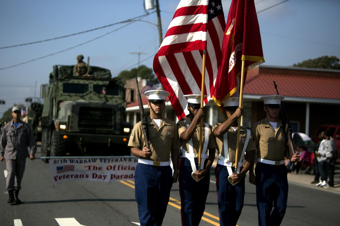 Marines with Headquarters and Support Battalion, Marine Corps Installations - East march as the color guard during the Warsaw Veterans Day Parade