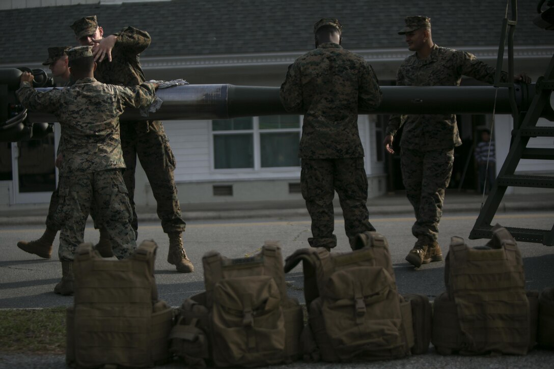 Marines with 1st Battalion, 10th Marine Regiment, 2d Marine Division clean the barrel of a M777A2 Howitzer before the start of the Warsaw Veteran’s Day Parade