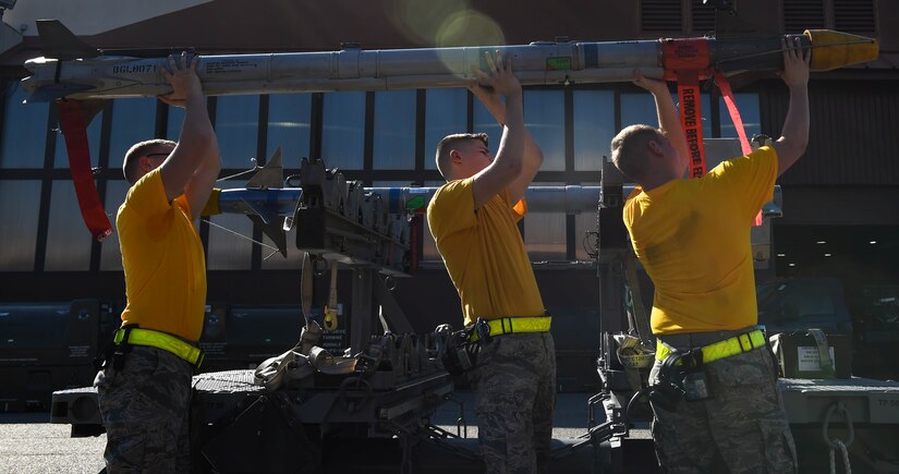 The 27th Aircraft Maintenance Unit load crew lift an AIM-9X missile during the 3rd Quarter Weapons Load Competition at Joint Base Langley-Eustis, Va., Nov. 3, 2017.