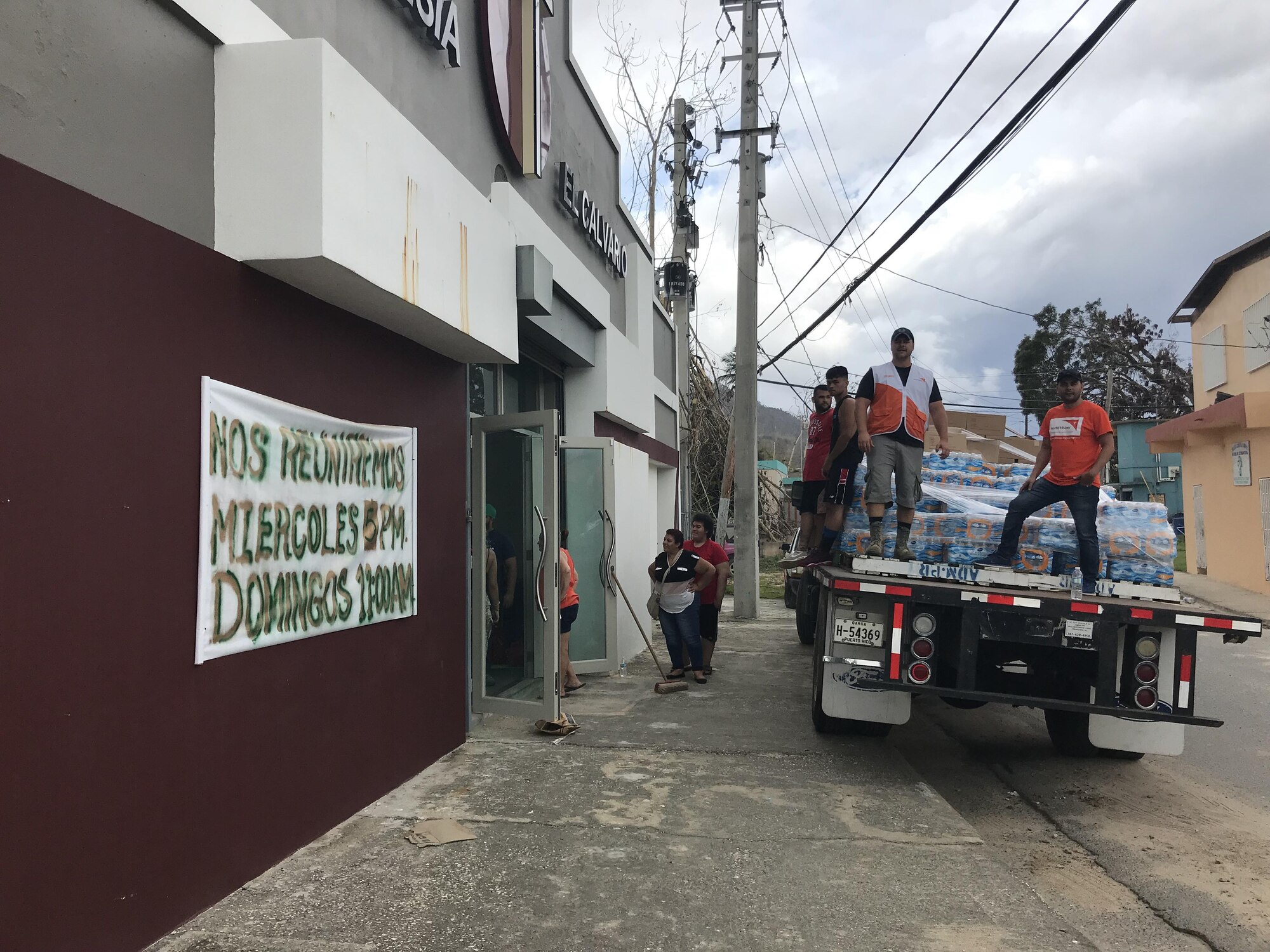 UTUADO, Puerto Rico – Richard Dessert, second from right, a Washington Air National Guard master sergeant, prepares to unload relief supplies gathered from the Puerto Rico National Guard distribution point in Utuado to a staging point at the El Calvario Church Oct. 5, 2017.  Dessert volunteered to deploy in support of his civilian employer, World Vision, to provide Hurricane Maria relief and IT support.  (Courtesy photo by Richard Dessert)