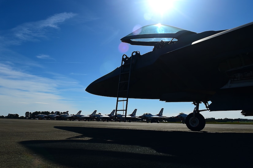 F-22 Raptor sits on runway across from Thunderbirds