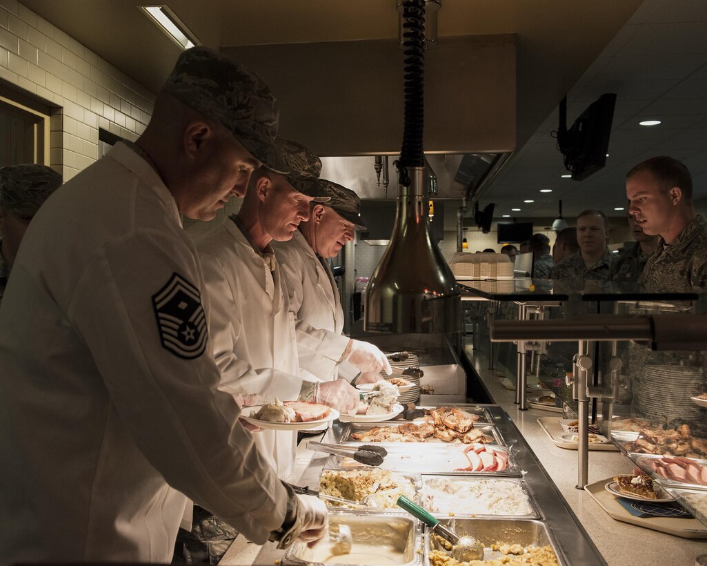 Senior Master Sgt. Jeffery Wiyrick, first sergeant for the 141st Air Refueling Wing, serves a holiday lunch alongside Command Chief Master Sgt. David Bishop and Col. Mark Fischer, 141st vice wing commander, Nov. 4, 2017 in the Warrior Dining Facility on Fairchild Air Force Base, Wash. More than 600 Airmen and Soldiers were served a holiday lunch over the November Unit Training Assembly weekend. (U.S. Air National Guard photo by Staff Sgt. Rose M. Lust/Released)