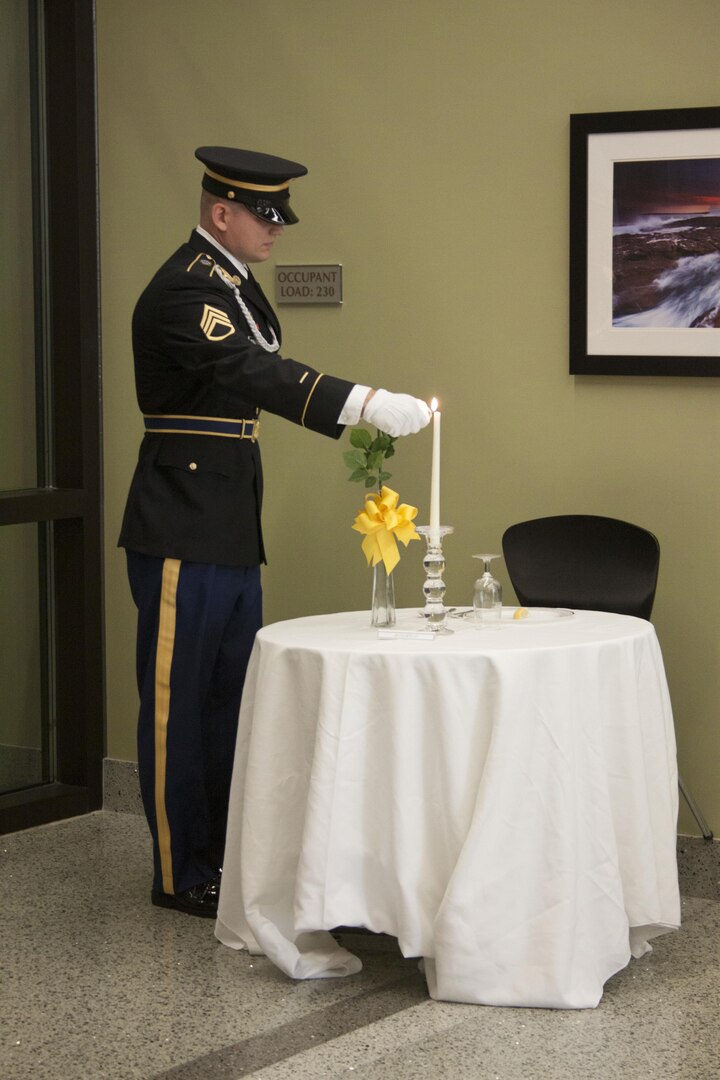 Army Staff Sgt. William Fernandez arranges items on DLA Distribution’s Missing Man Table.