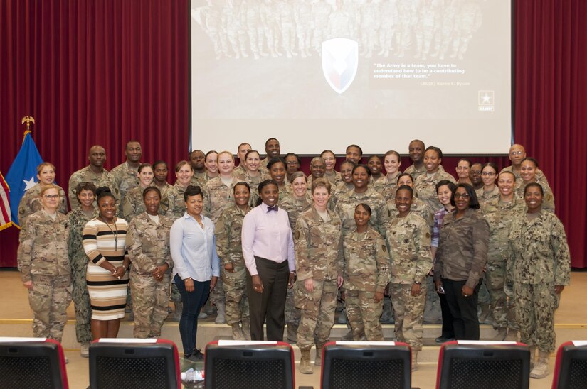 Group of female Soldiers and civilians pose for a photo.