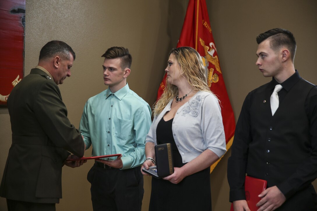 U.S. Marine Brig. Gen. Kurt W. Stein (center left), Director of Marine and Family Programs, Manpower and Reserve Affairs, presents Silver Star to Lance Cpl. Donald J. Cline’s wife, Tina Cline (center right) and sons Dylan Cline (left) and Dakota Cline (right), during a Silver Star Award ceremony in his honor on Marine Corps League Detachment 1419, Mandan, North Dakota, Nov 1, 2017.