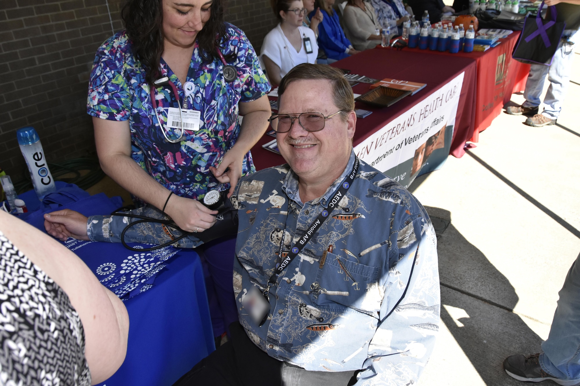A healthcare professional takes the blood pressure of an AEDC team member, Michael Glennon, during the Arnold Air Force Base Community Health Fair Sept. 29 in front of the Arnold Air Force Base Exchange and Commissary. More than 10 healthcare exhibitors from several community partners to include the Coffee County Health Department, Veteran’s Affairs, Red Cross and Tennova Hospital, participated in the health fair. (U.S. Air Force photo/Rick Goodfriend) (This image was manipulated by obscuring badges for security purposes.)