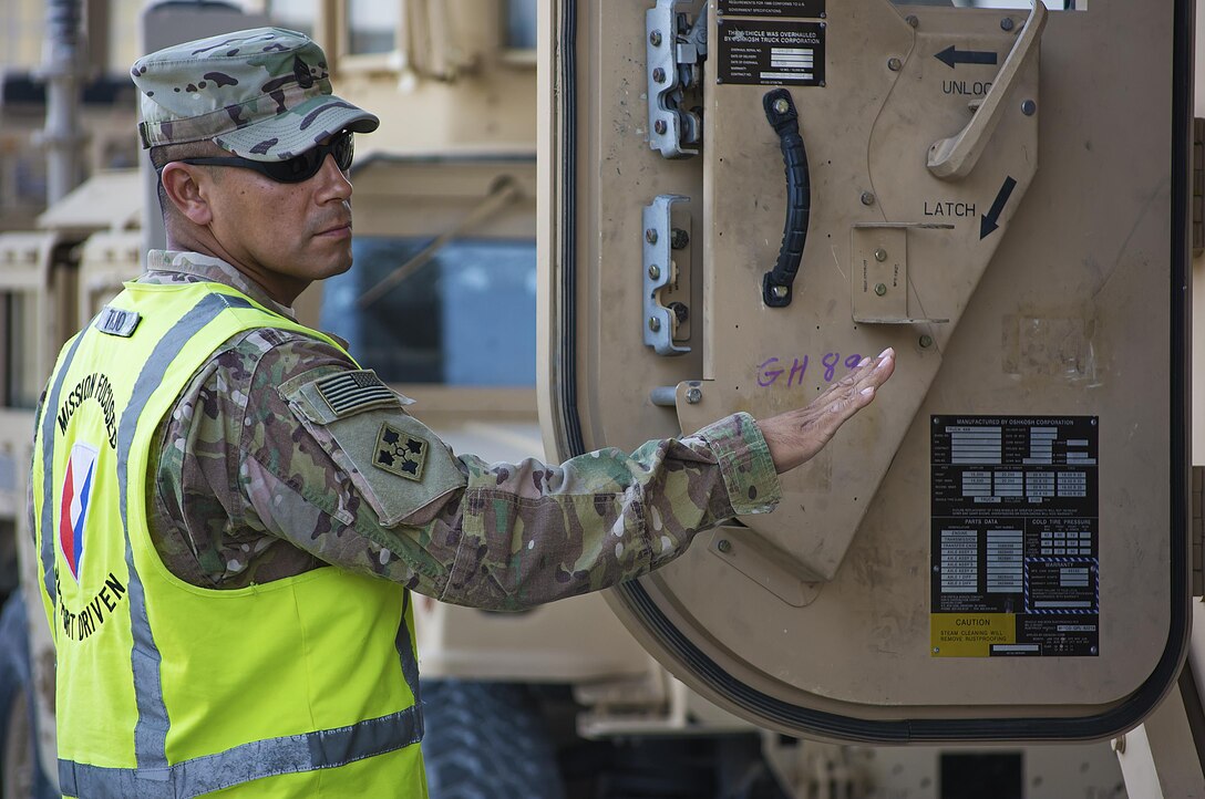 Sgt. First Class Christopher Trejo, contract officer representative, Army Field Support Battalion-Kuwait, inspects a vehicle during a quality assurance inspection at Camp Arifjan, Kuwait, July 25. (U.S. Army Photo by Justin Graff, 401st AFSB Public Affairs)