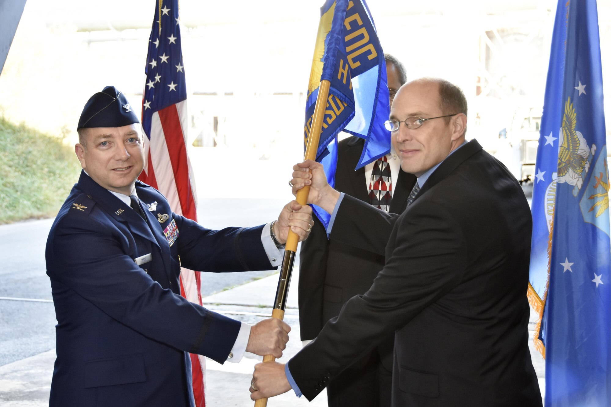 Lance E. Baxter, right, becomes director of the Hypersonic Systems Combined Test Force during a Change of Directorship Ceremony Oct. 20 in the J-5 Large Rocket Motor Test Facility at Arnold Air Force Base. Col. Timothy West, chief of Test Operations Division, passes the Hypersonic Systems CTF guidon to Baxter. (U.S. Air Force photo/Rick Goodfriend)