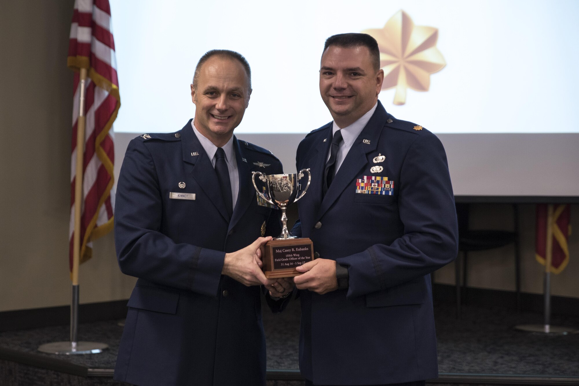 Maj. Casey Eubanks accepts the Field Grade Officer of the Year award from Col. Robert Kinney, 188th Wing commander, Nov. 4, 2017, at Ebbing Air National Guard Base, Fort Smith, Ark. The award is given to airmen that have provided exceptional service to the wing throughout the last year and distinguished themselves among the best in the 188th. Winners were selected in the Airman, Noncommissioned Officer, Senior NCO, First Sergeant, CGO and Field Grade Officer categories. (U.S. Air National Guard photo by Tech. Sgt. Daniel Condit)