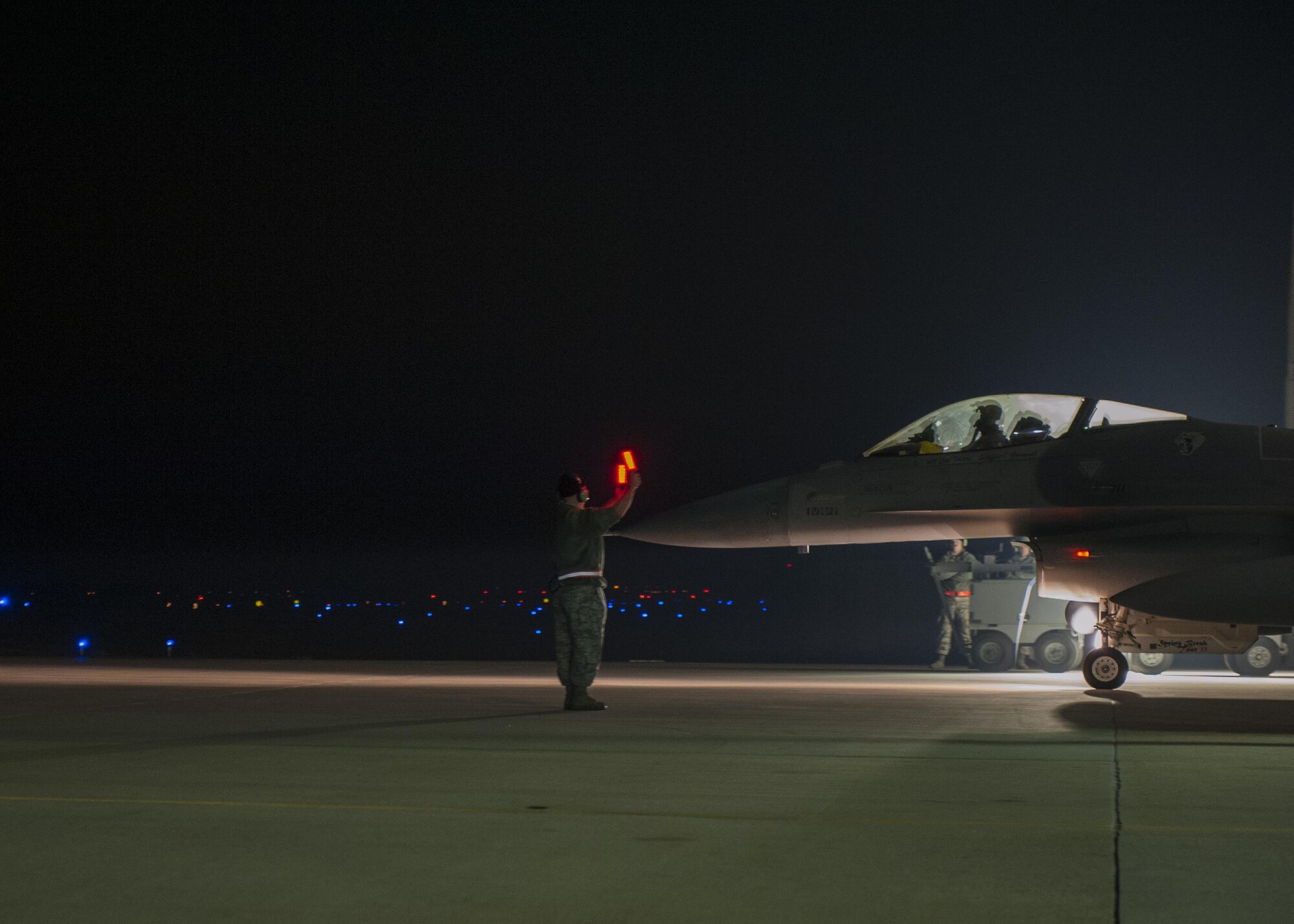 An Airman with the Wisconsin Air National Guard’s115th Fighter Wing marshals an F-16 Fighting Falcon onto the taxiway at Kunsan Air Base, Republic of Korea, Nov. 4, 2017. The aircraft departed early in the morning for their journey back to Wisconsin after a three month deployment in support of a U.S. Pacific Command Theater Security Package. (U.S. Air Force photo by Capt. Christopher Mesnard)