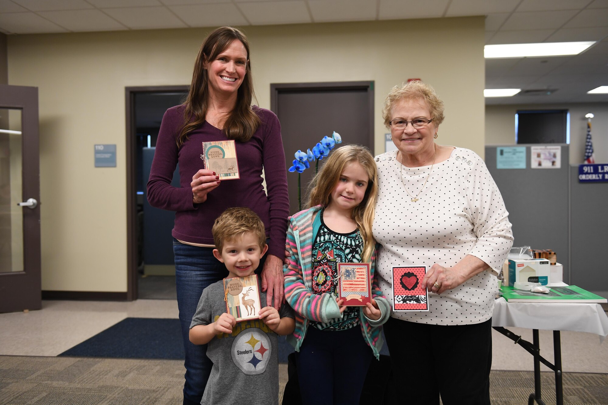 A family holds up greeting cards at the Pittsburgh International Airport Air Reserve Station, Pa., November 5th, 2017. They were participating in a card-making event hosted by the 911th Logistics Readiness Squadron which helped families create greeting cards for deployed service members. (U.S. Air Force photo by Senior Airman Beth Kobily)