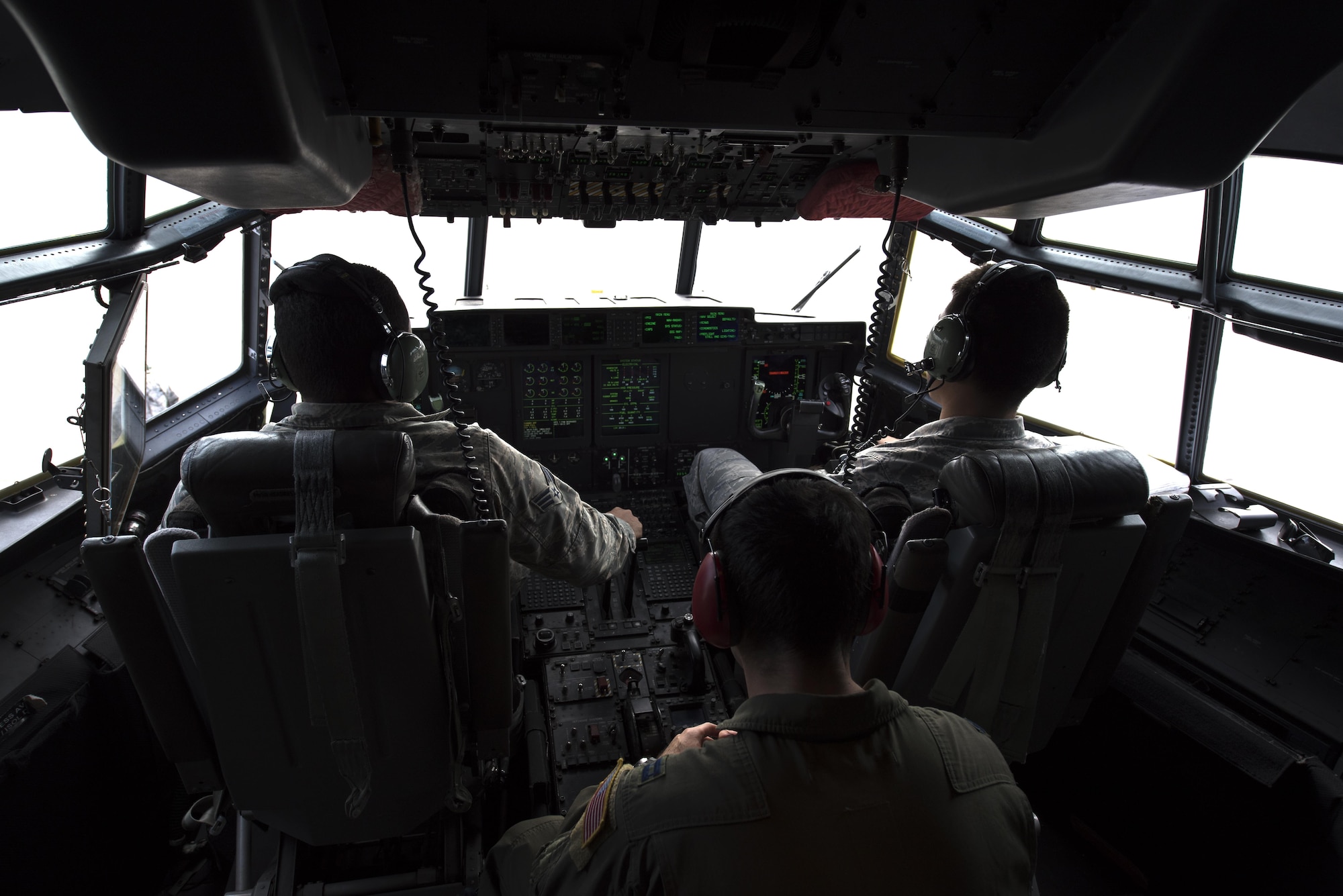 U.S. Airmen assigned to the 86th Aircraft Maintenance Squadron and 37th Airlift Squadron sit in the pilot seats of a C-130J Super Hercules during taxi to a parking spot on Ramstein Air Base, Germany, Oct. 13, 2017. Crew chiefs are responsible for preparing the aircraft for the next mission. (U.S. Air Force photo by Airman 1st Class Devin M. Rumbaugh)
