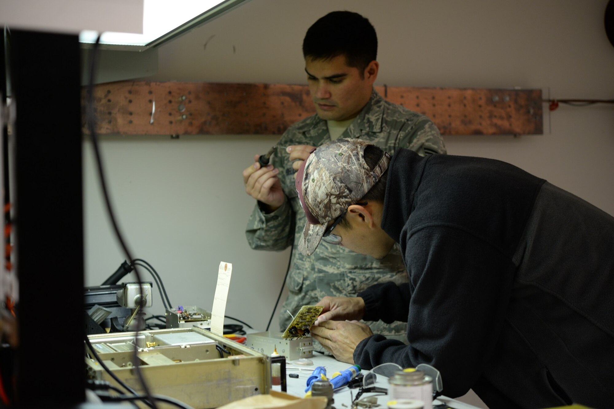 Senior Airman Jacob Hoeltje and Mark Kenner, 14th Operations Support Squadron Radar, Airfield and Weather Systems Flight (RAWS) technicians, fix a communications piece Nov. 3, 2017, on Columbus Air Force Base, Mississippi. Staff Sgt. Andrew Snyder, 14th OSS RAWS Assistant Noncommissioned Officer in Charge, said the 1C8X1 Radar and 1C8X2 Airfield Systems career fields merger Nov. 1, 2017, means more qualified technicians are now able to be spread across the RAWS mission. (U.S Air Force photo by Airman 1st Class Keith Holcomb)