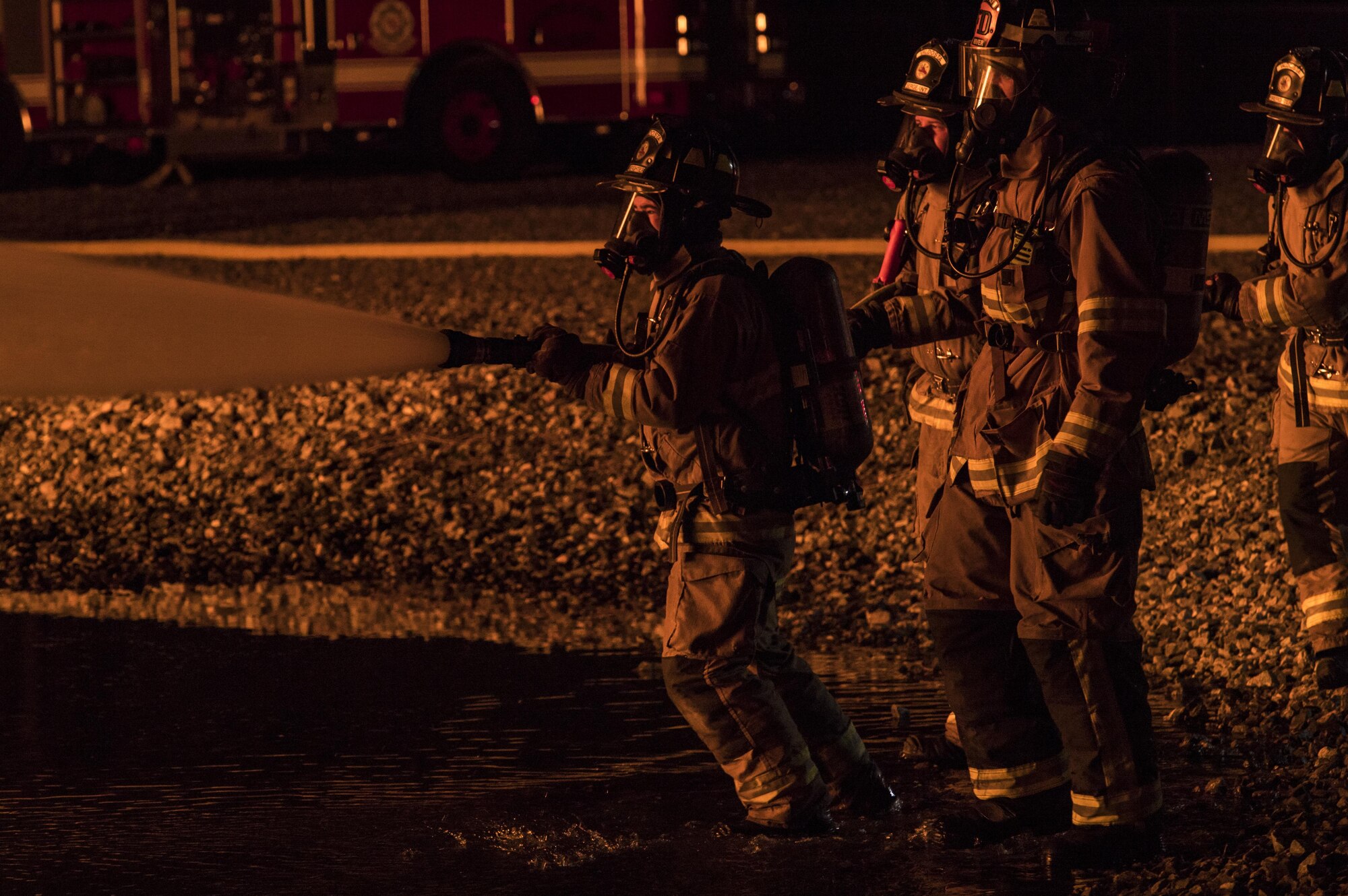 Firefighters from Moody and the Valdosta Fire Department put out a blaze during nighttime live-fire training, Nov. 8, 2017, at Moody Air Force Base, Ga. In addition to combatting fires outside the prop aircraft, firefighters had to enter and combat the fires inside. (U.S. Air Force photo by Senior Airman Janiqua P. Robinson)