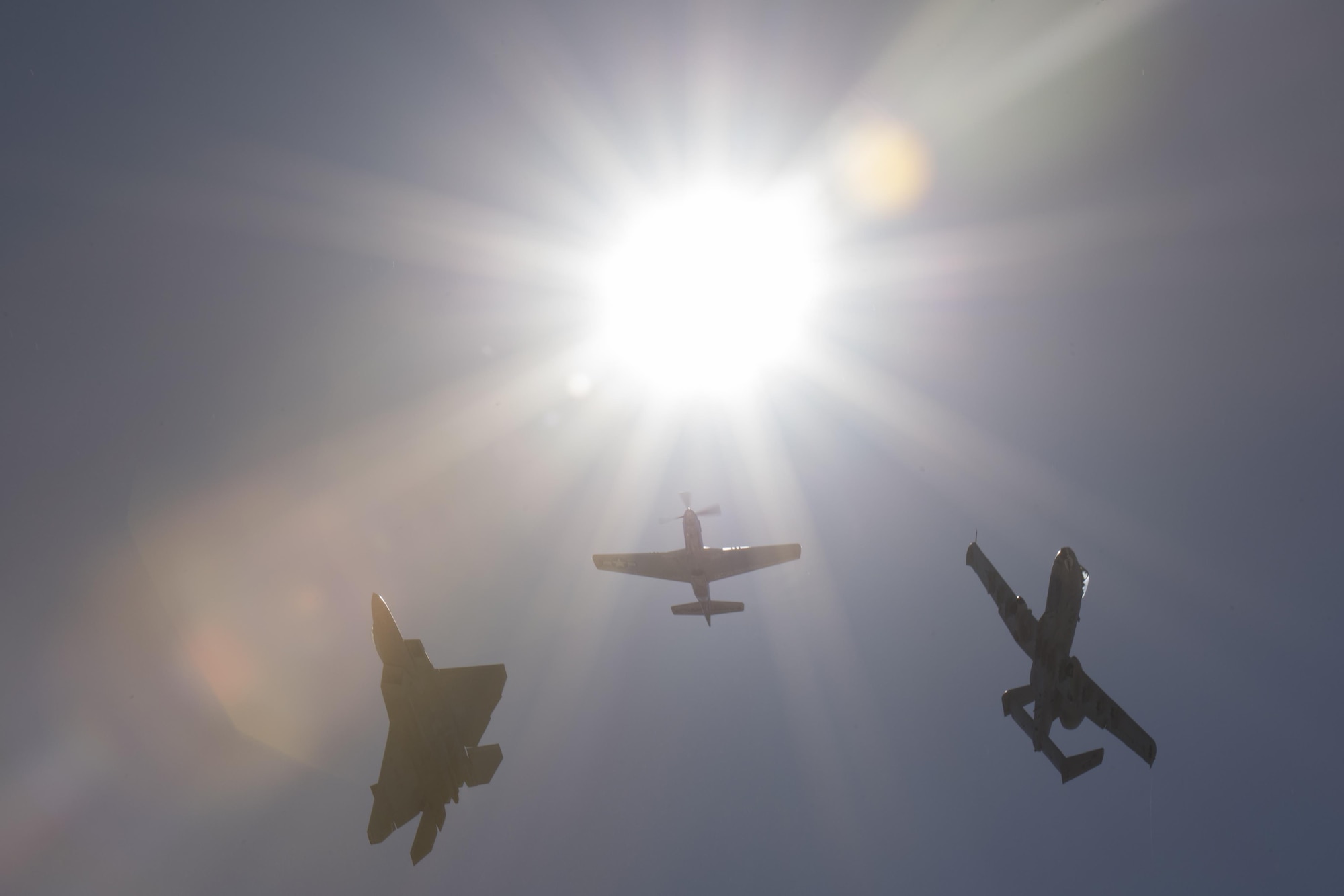 A P-51 Mustang, a F-22 Raptor and an A-10C Thunderbolt II, break formation after completing a heritage flight, Nov. 3, 2017, at Naval Air Station Jacksonville, Fla. The U.S. Air Force Heritage Flight program showcases past, present and future aircraft to spectators at air shows around the world. (U.S. Air Force photo by Staff Sgt. Eric Summers Jr.)