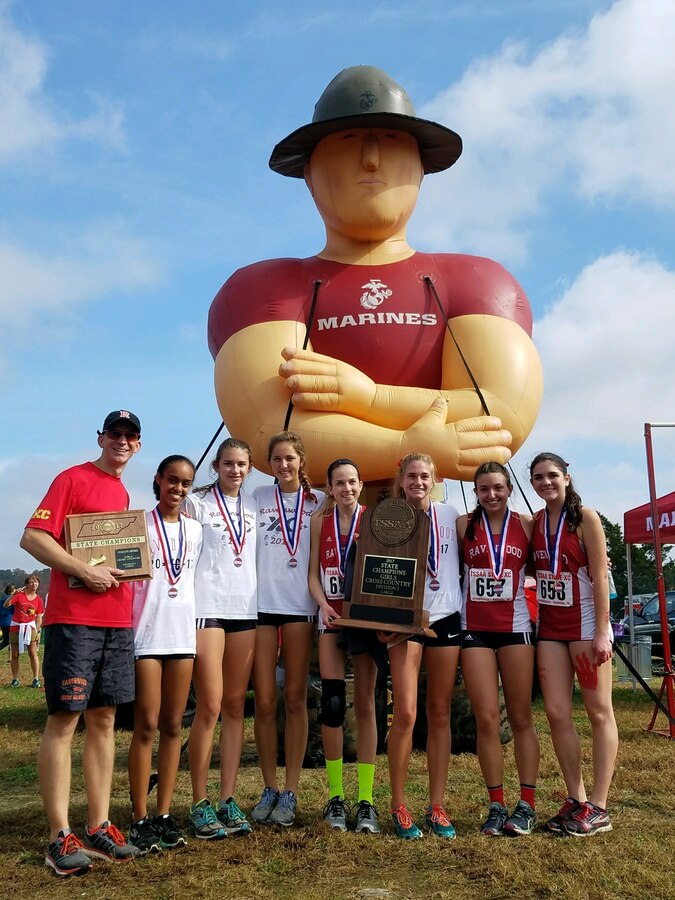 Ravenwood High School’s girls’ cross country team stands in front of an inflatable Marine drill instructor at Percy Warner Park Steeplechase Course in Nashville, Tennessee, Nov. 4, 2017. They are the Tennessee Secondary School Athletic Association State Cross Country Champions of Division 1 Large. (U.S. Marine Corps courtesy photo)