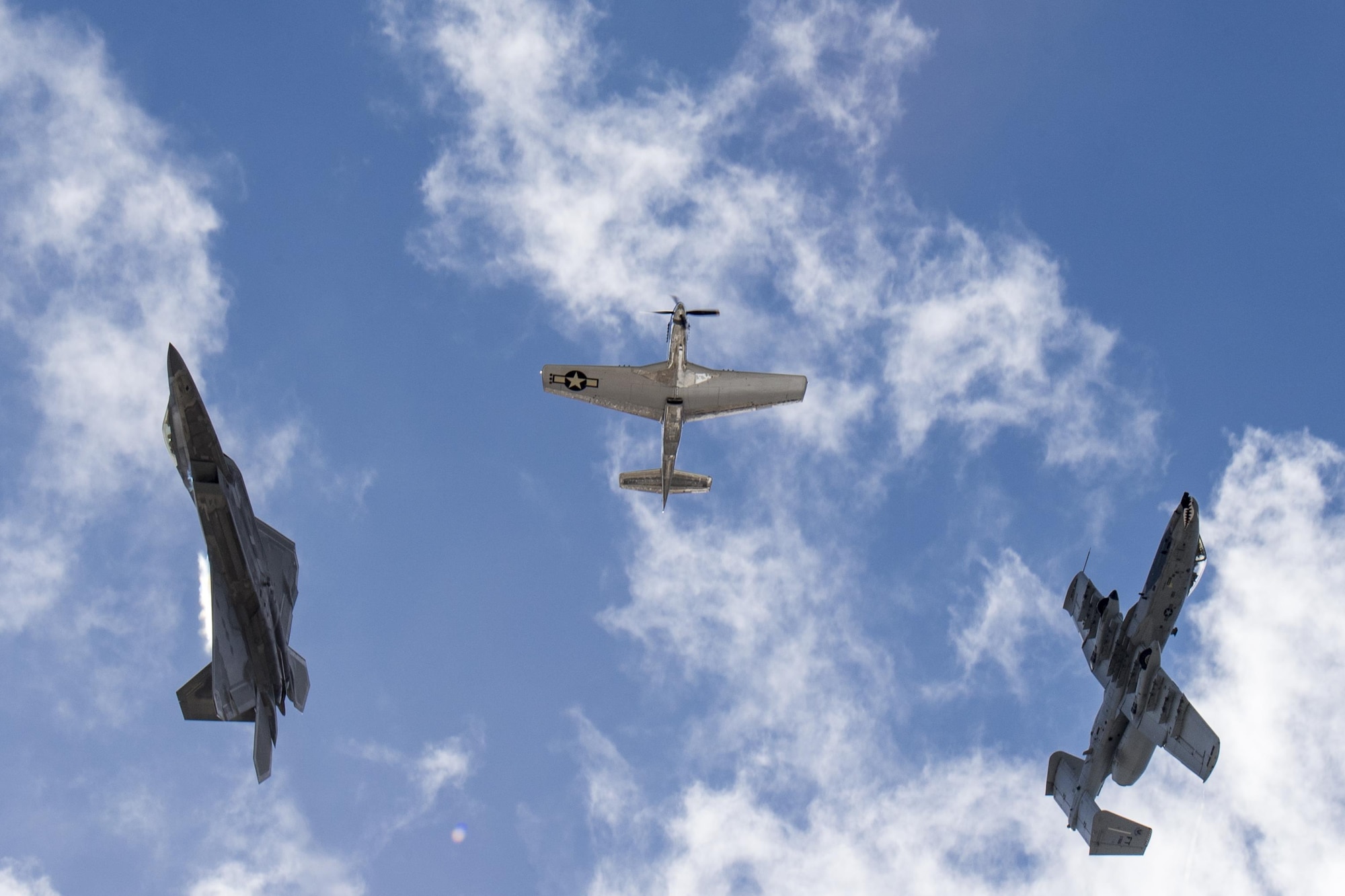 A P-51 Mustang, A-10C Thunderbolt II and an F-22 Raptor break after completing the heritage flight, Nov. 5, 2017, at Naval Air Station Jacksonville, Fla. The U.S. Air Force Heritage Flight program showcases past, present and future aircraft to spectators at air shows around the world. (U.S. Air Force photo by Staff Sgt. Eric Summers Jr.)