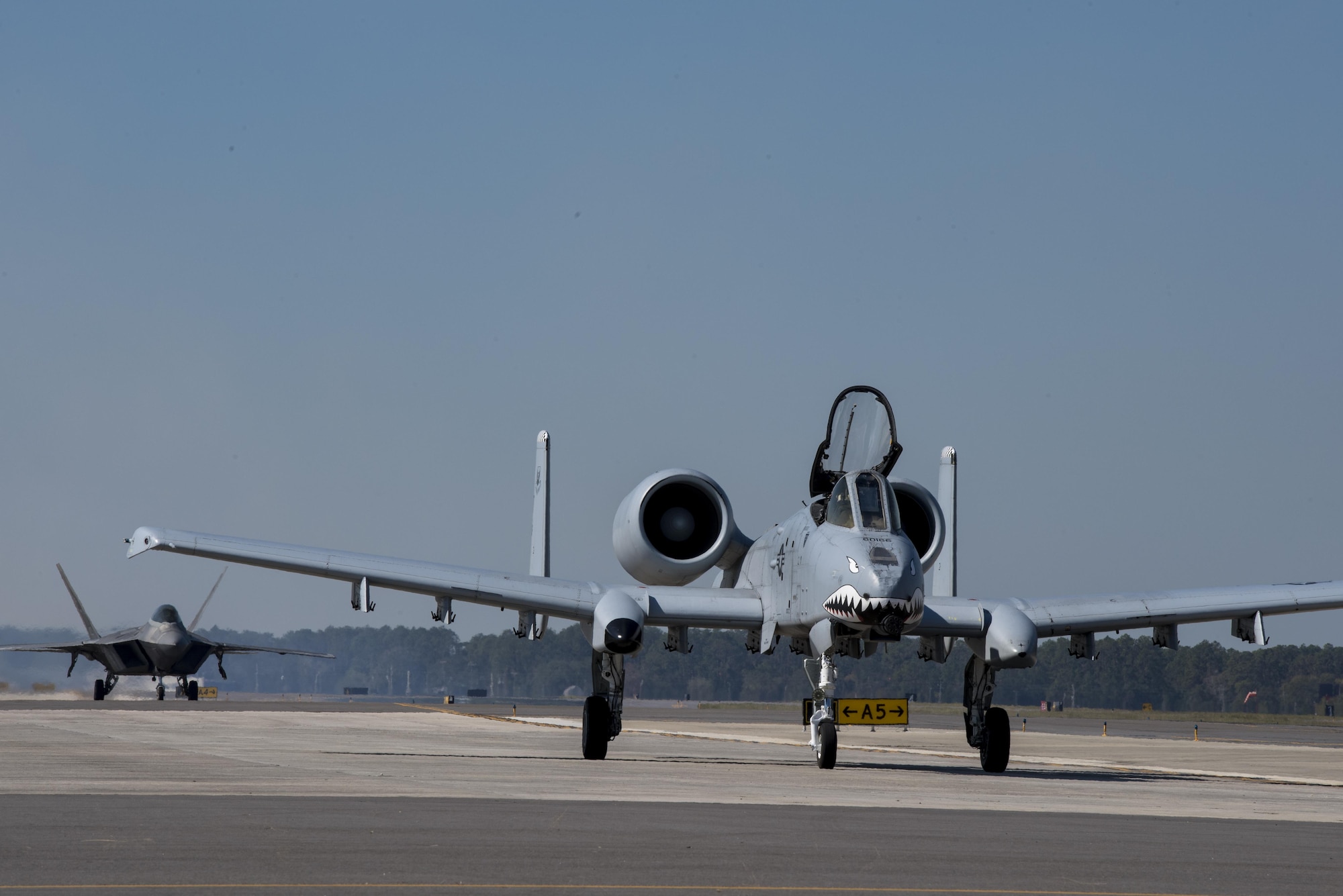 An A-10C Thunderbolt II and a F-22 Raptor taxi in front of the crowd after performing a heritage flight, Nov. 4, 2017, at Naval Air Station Jacksonville, Fla. The U.S. Air Force Heritage Flight program showcases past, present and future aircraft to spectators at air shows around the world. (U.S. Air Force photo by Staff Sgt. Eric Summers Jr.)