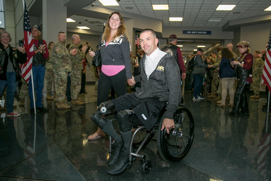 A wounded warrior in a wheelchair poses for a photograph.