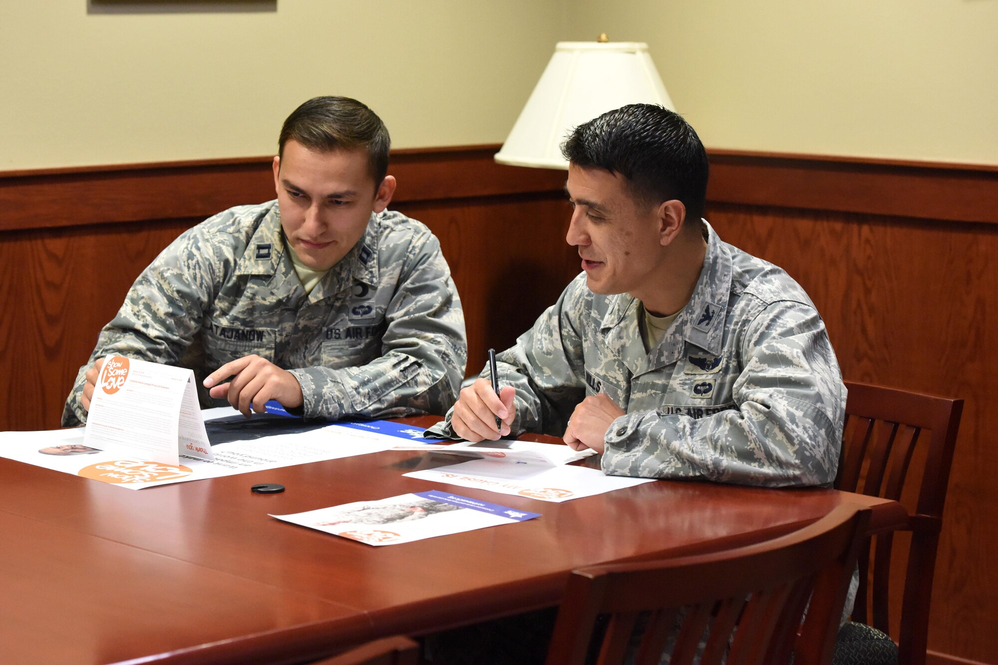 U.S. Air Force Col. Ricky Mills, 17th Training Wing commander, and Capt. Iskandar Atajanow 17th TRW chaplain, sign a Combined Federal Campaign paper pledge, donating to a charity of their choice, as an official start to this year’s campaign at the Norma Brown building on Goodfellow Air Force Base, Texas, Nov. 8, 2017. This year, anyone wanting to sign up for the campaign may do so either with the pledge form or on the campaign’s website. (U.S. Air Force photo by Airman 1st Class Seraiah Hines/Released)