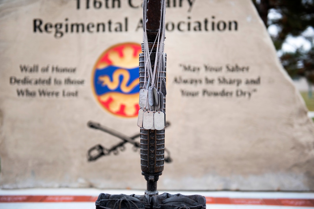 Service member dog tags are displayed during a Veterans Day ceremony.