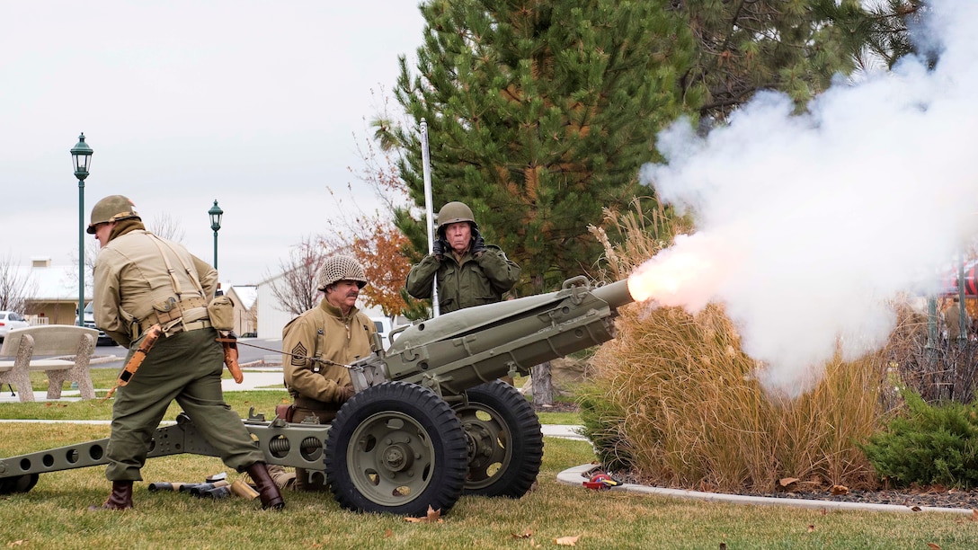 National Guardsmen fire a cannon during a Veterans Day ceremony.