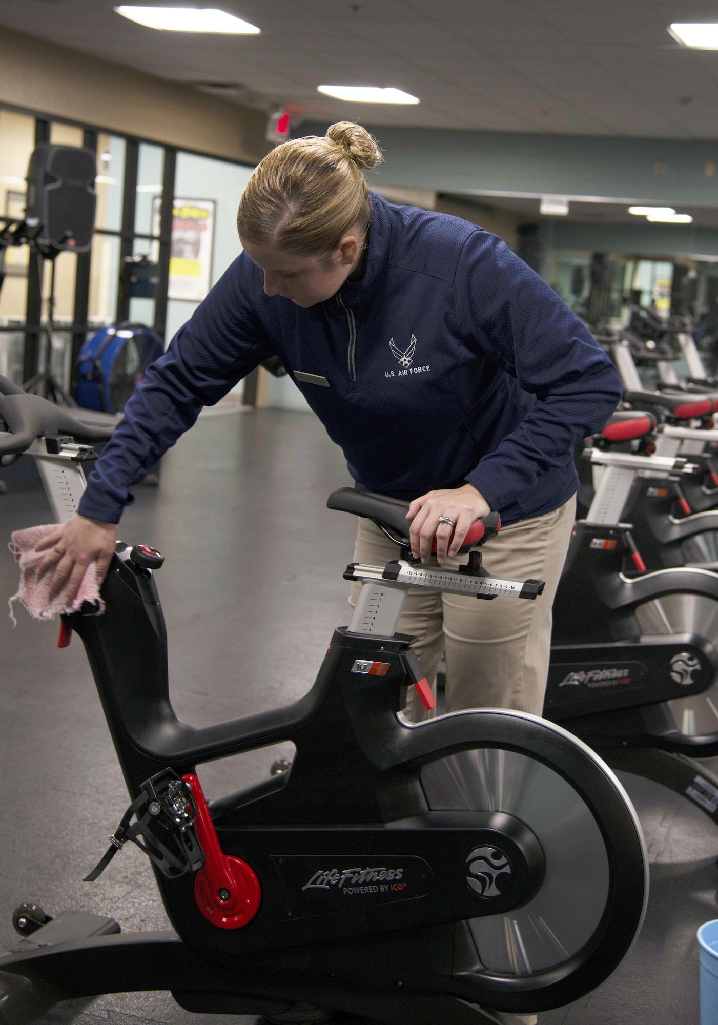 U.S. Air Force Senior Airman Sage Iverson, a fitness specialist assigned to the 6th Force Support Squadron, wipes down a spin machine at MacDill Air Force Base, Fla., Nov. 8, 2017.