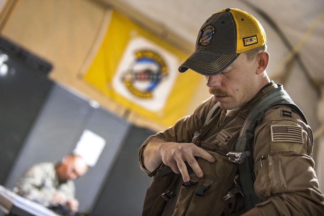 An airman reaches into the pocket of his clothing.