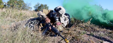 Avoiding simulated enemy fire and a chemical gas attack, Sgt. Rolando Fender from the Airborne and Ranger Training Brigade makes his way towards an injured Soldier while at the chemical, biological, radiological and nuclear (CBRN) defense lane. Photo by Jose E. Rodriguez, AMEDDC&S