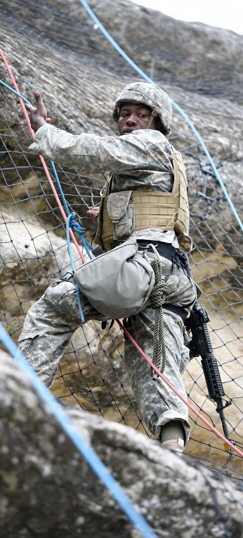 Staff Sgt.Lionel Semon, assigned to the Airborne and Ranger Training Brigade, climbing up the side of a cliff.