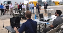 IMAGE: DAHLGREN, Va. (Sept. 12, 2017) - Navy engineers Michael Parkison and Kevin Green operate the Weaponized Autonomous System Prototype (WASP) and Collaborative Aerial Network for the Autonomous Remote Engagement System (CANARES) at the command and control station after the Sly Fox Mission 22 demonstration of the CANARES rapid prototype. In the background, Navy scientist Jamshaid 'JD' Chaudhry briefs visitors on WASP at the Naval Surface Warfare Center Dahlgren Division sponsored event.
