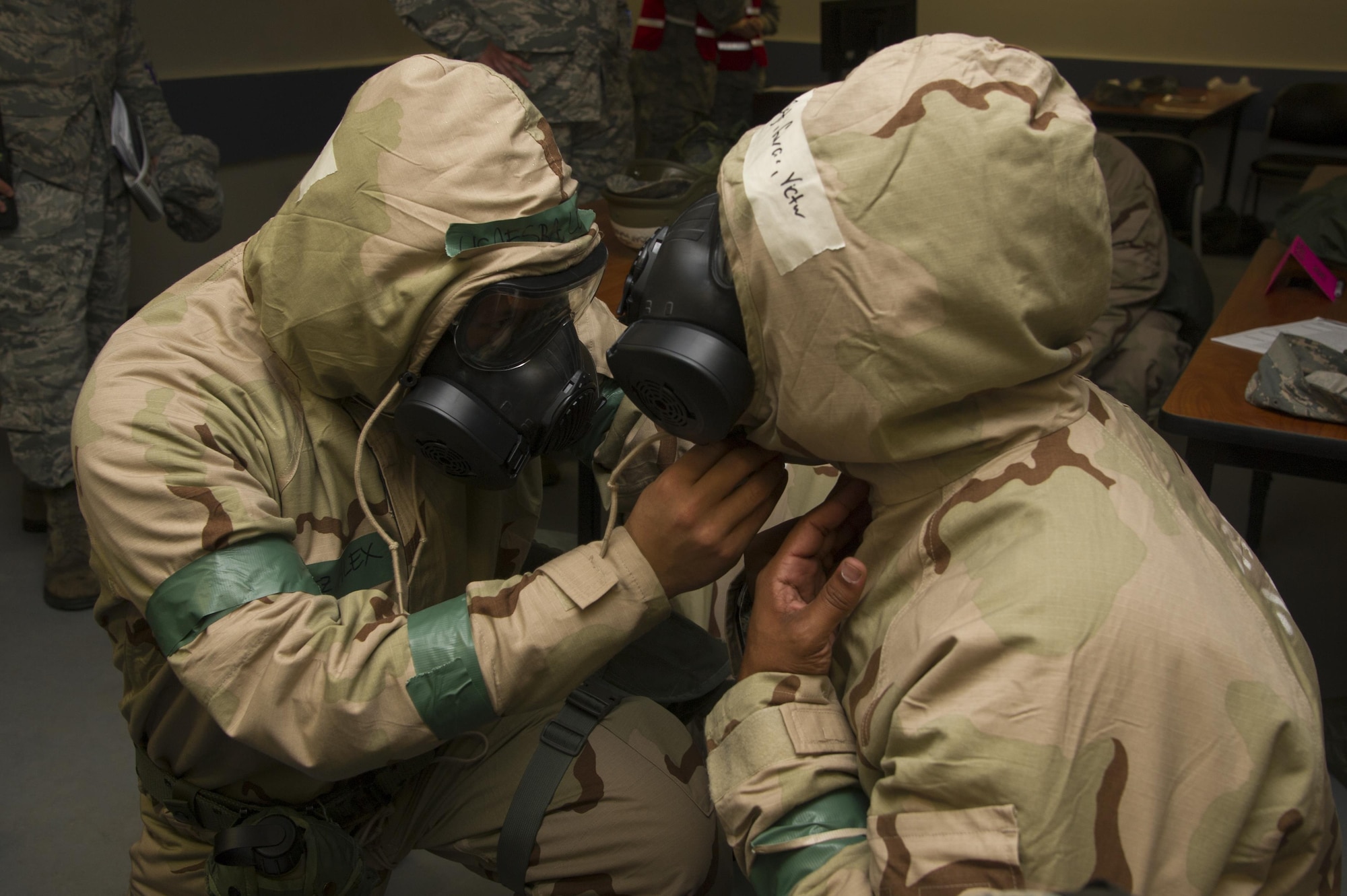Senior Airman Alex Lopez checks Staff Sgt. Victor Garcia’s gas mask and hood during an exercise Nov. 4 at Beale Air Force Base. Squadron. Both Airmen, assigned to the 940th Force Support Squadron, practiced readiness skills in the Ability to Survive and Operate exercise. (U.S. Air Force photo by Senior Airman Tara R. Abrahams)