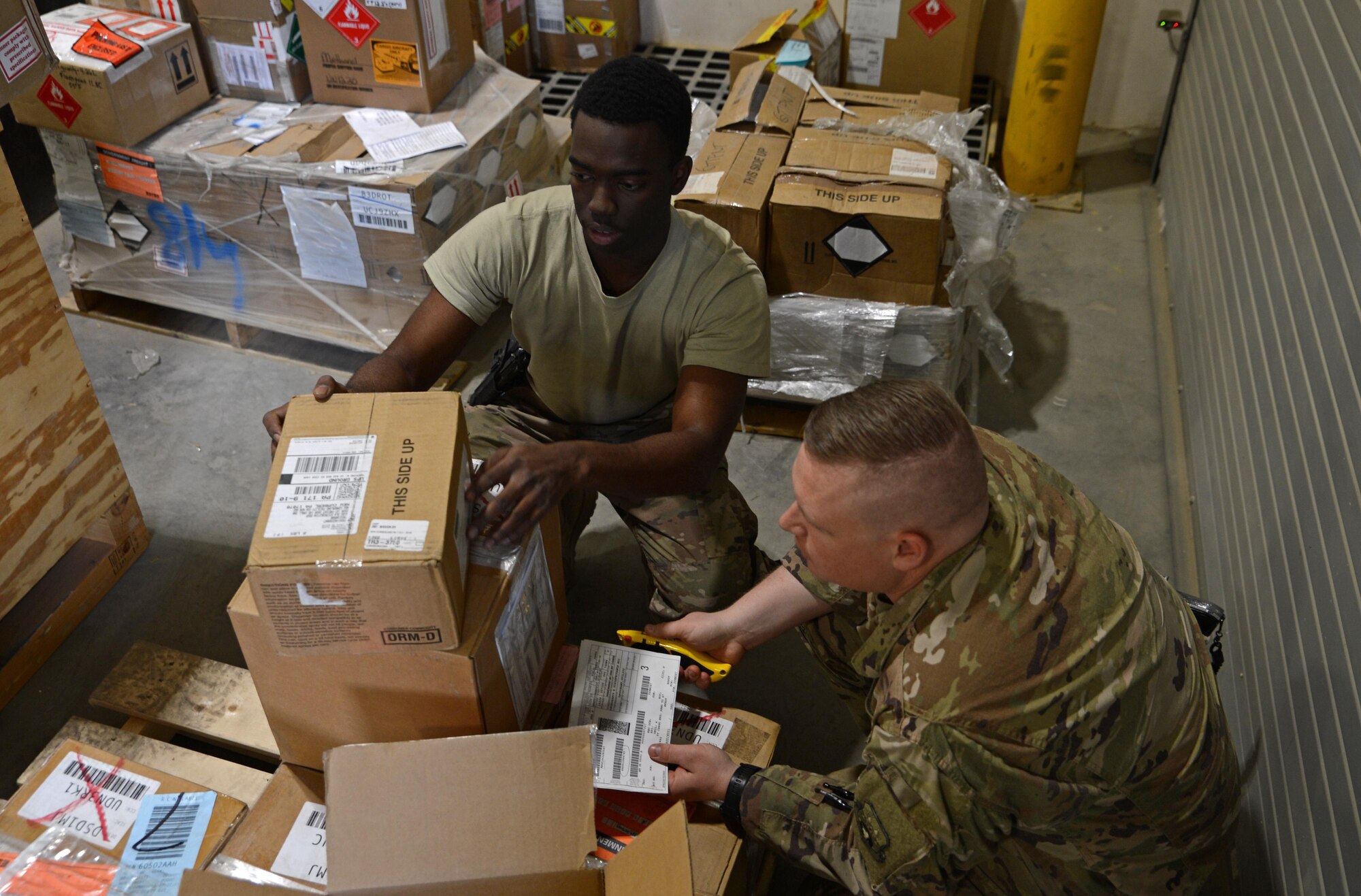 1st Lt. Joshua White (right), 455th Expeditionary Logistics Readiness Squadron officer, and Airman 1st Class Trevis Pridgen (center), 455th Expeditionary Logistics Readiness Squadron traffic management journeyman,  verifies the quantity of a product Nov. 4, 2017 at Bagram Airfield, Afghanistan.