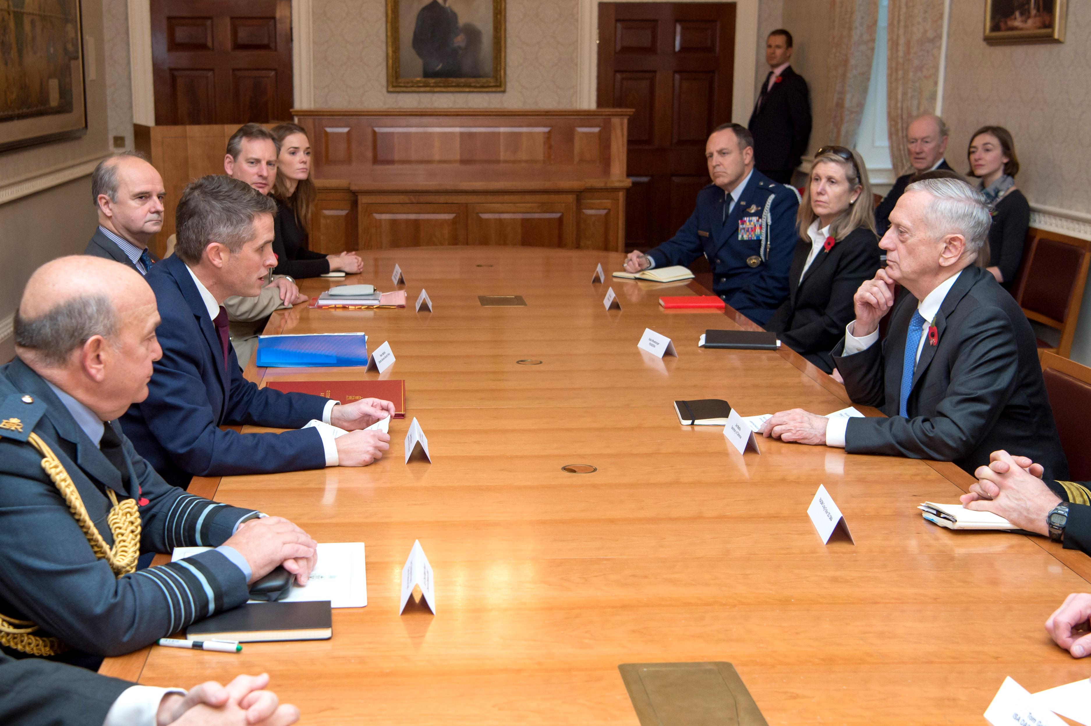 Defense Secretary Jim Mattis sits at a table with other people.