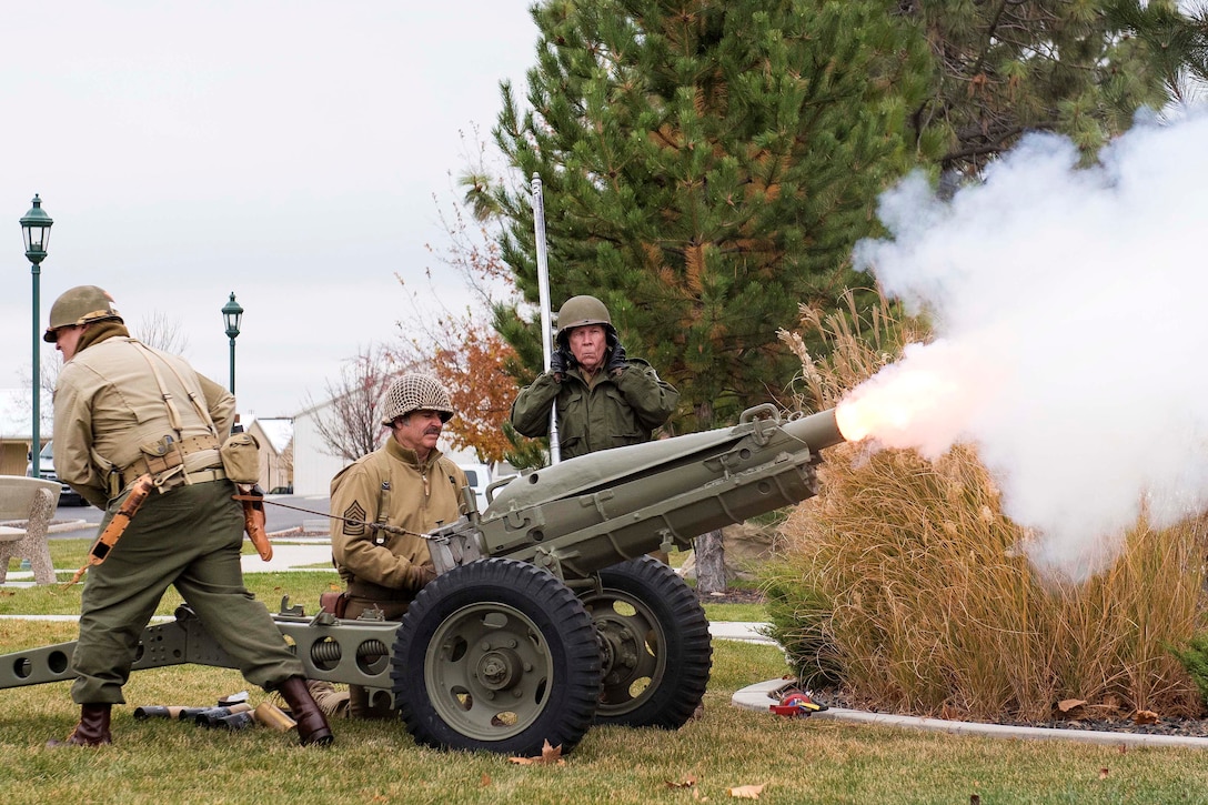 National Guardsmen fire a cannon during a Veterans Day ceremony.